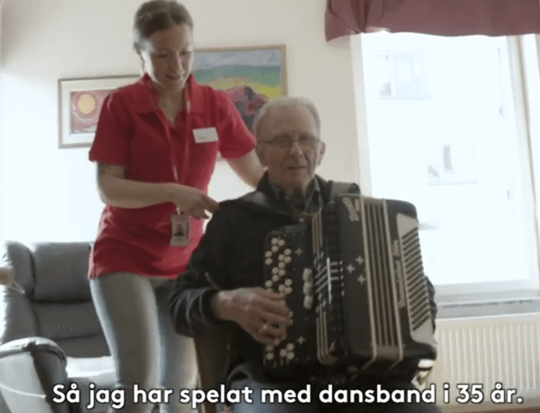 Omsorgstagare Gustav spelar dragspel när Vardagas hemtjänstpersonal är på besök