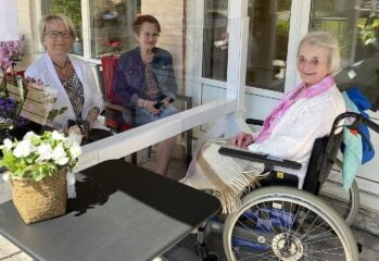 Toborg och två anhöriga träffas utomhus avskilda med en glas-skiva