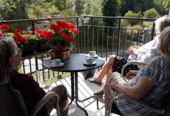 Tre personer sitter på en balkong