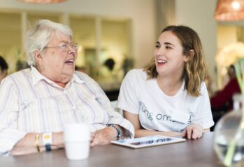 En ung och en äldre person skrattar tillsammans