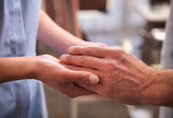 En gammal persons hand undersöks av en sköterska