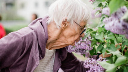 En person luktar på syréner