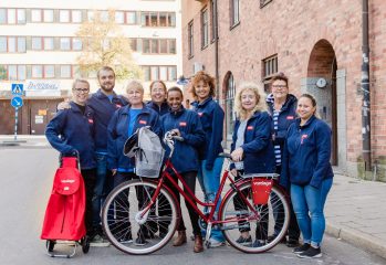 gruppbild på hemtjänstpersonal i blå kläder cykel längst fram