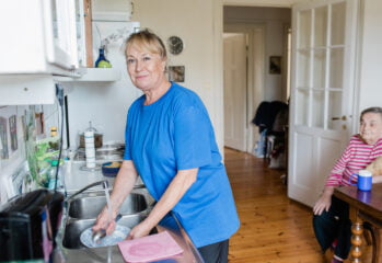 Medarbetare från hemtjänsten hjälper en omsorgstagare med disken