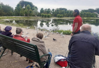 Fikapaus vid vatten där fåglar finns runt omkring de äldre