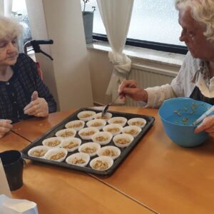 Två kvinnor bakar muffins hos hemtjänsten