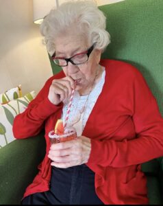 Äldre kvinna dricker vattenmelondrink