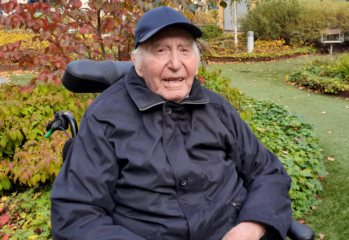 Porträtt äldre person i keps utomhus