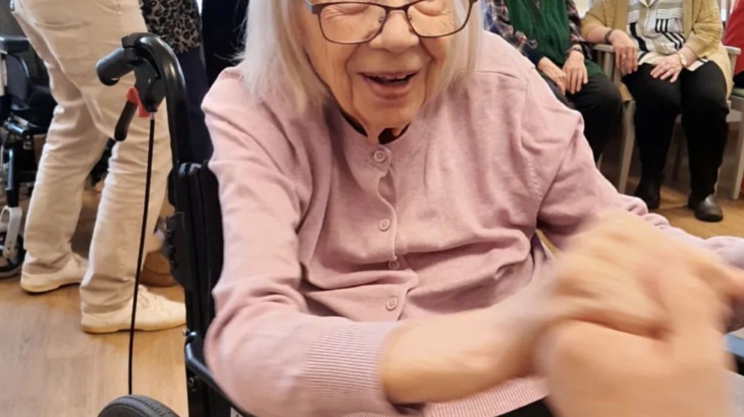 glad äldre kvinna i rullstol