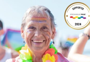 Äldre dam som ler i färggrant halsband