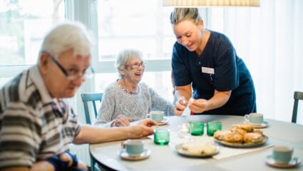 Kaffe hälls upp av personal till två boende