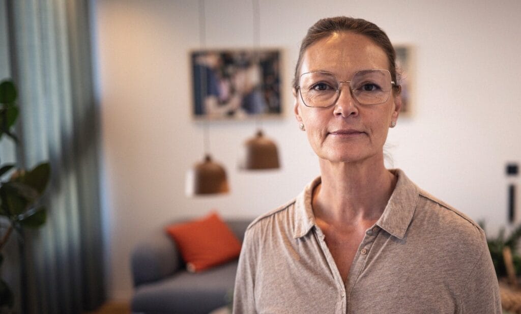 Personporträtt Sophia du Rietz håret i topps, glasögon och brun skjorta