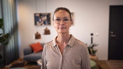 Personporträtt Sophia du Rietz håret i topps, glasögon och brun skjorta