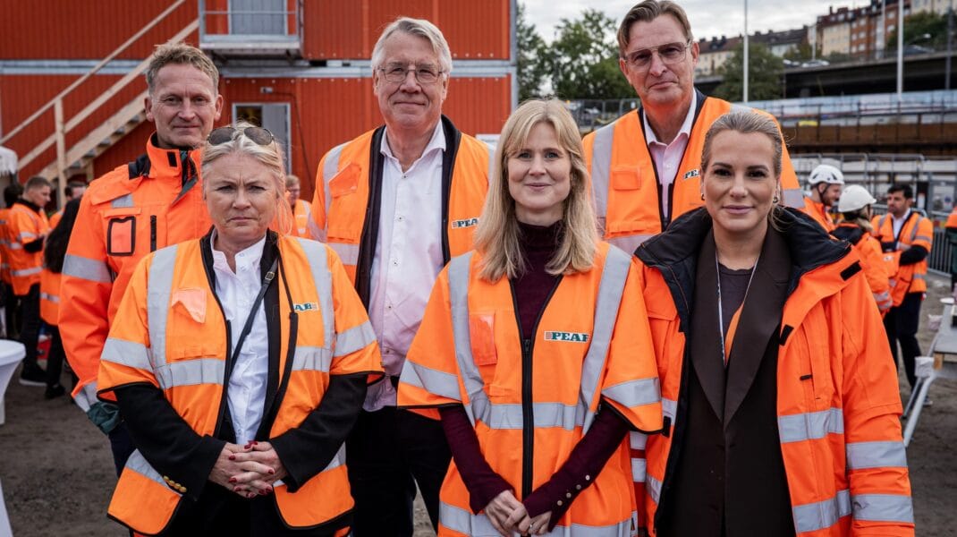 Gruppbild på representanter från stadsbyggnads- och idrottsborgarråd och Nytida i orange byggvästar