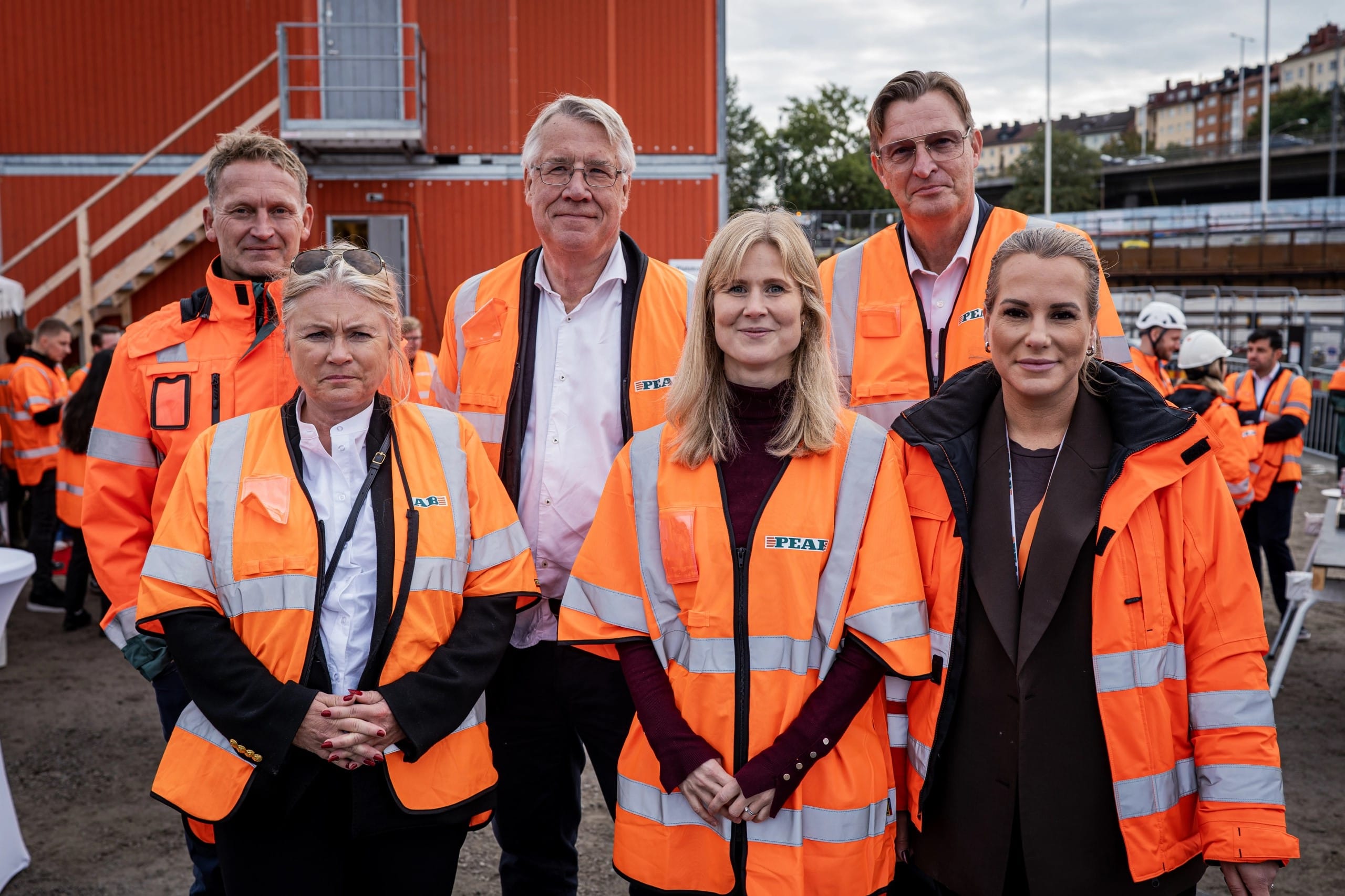 Gruppbild på representanter från stadsbyggnads- och idrottsborgarråd och Nytida i orange byggvästar