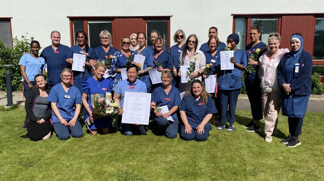 Gruppbild på medarbetare i blå arbetskläder utomhus