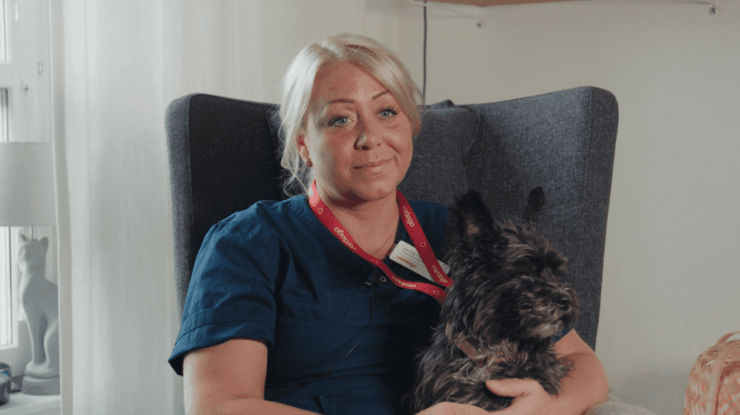 Porträtt Jennifer pettersson med hunden Rambo knät