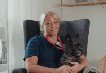 Porträtt Jennifer pettersson med hunden Rambo knät