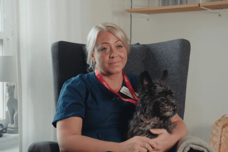 Porträtt Jennifer pettersson med hunden Rambo knät